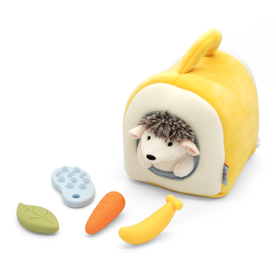 Yellow hedgehog-shaped pet house with a hedgehog plush toy inside, accompanied by small toys on a white background.